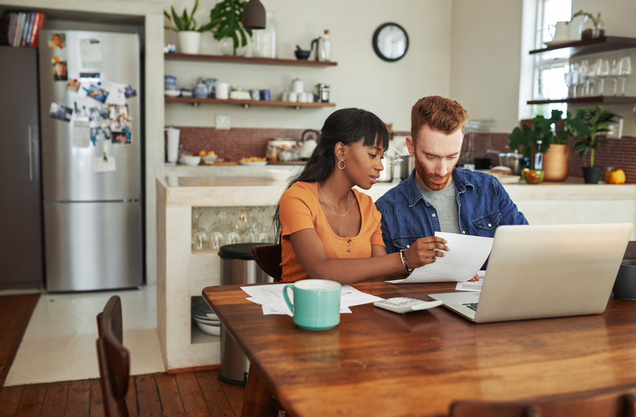 young couple scrutinize utility bills in their kitchen