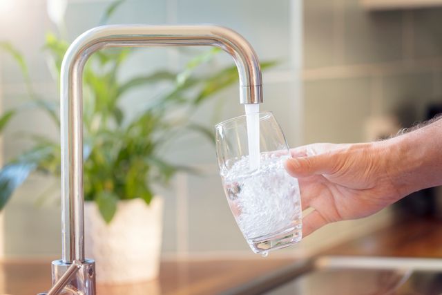 Front view of water coming from a luxury tap filling a glass up