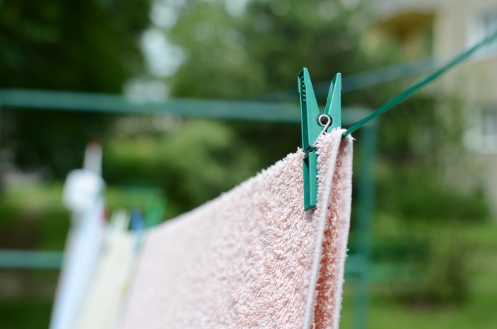 Hanging towel outdoors on a clothes line. 