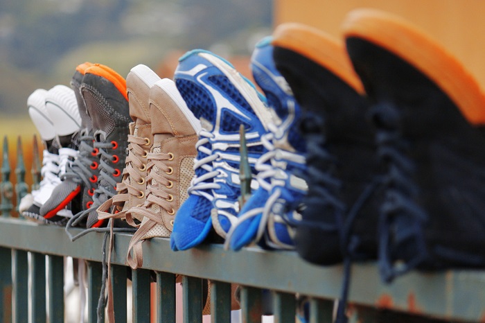 Running shoes drying on a fence.