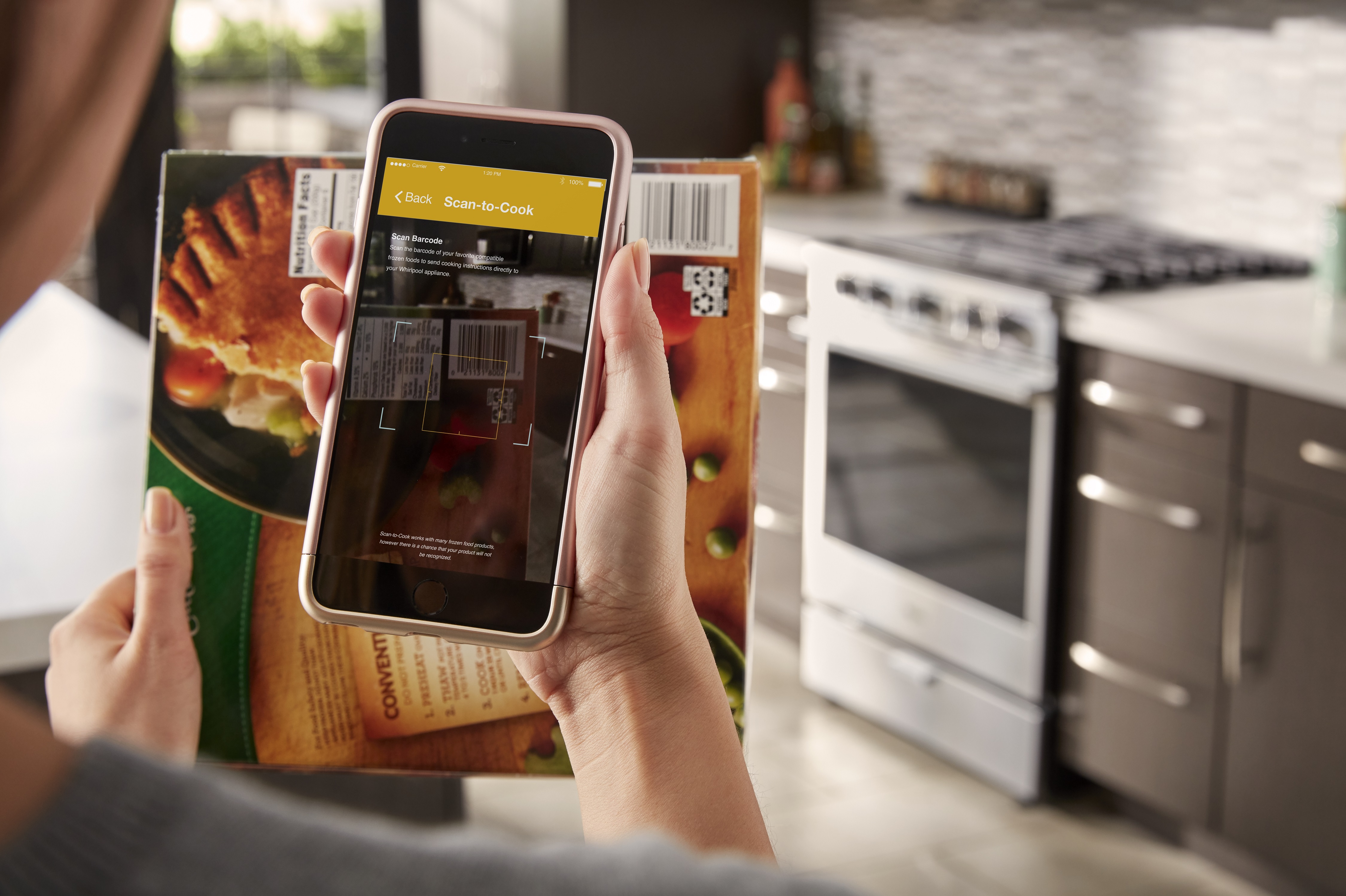 woman scans barcode on frozen food product in front of Whirlpool 30” Slide In Gas Range 