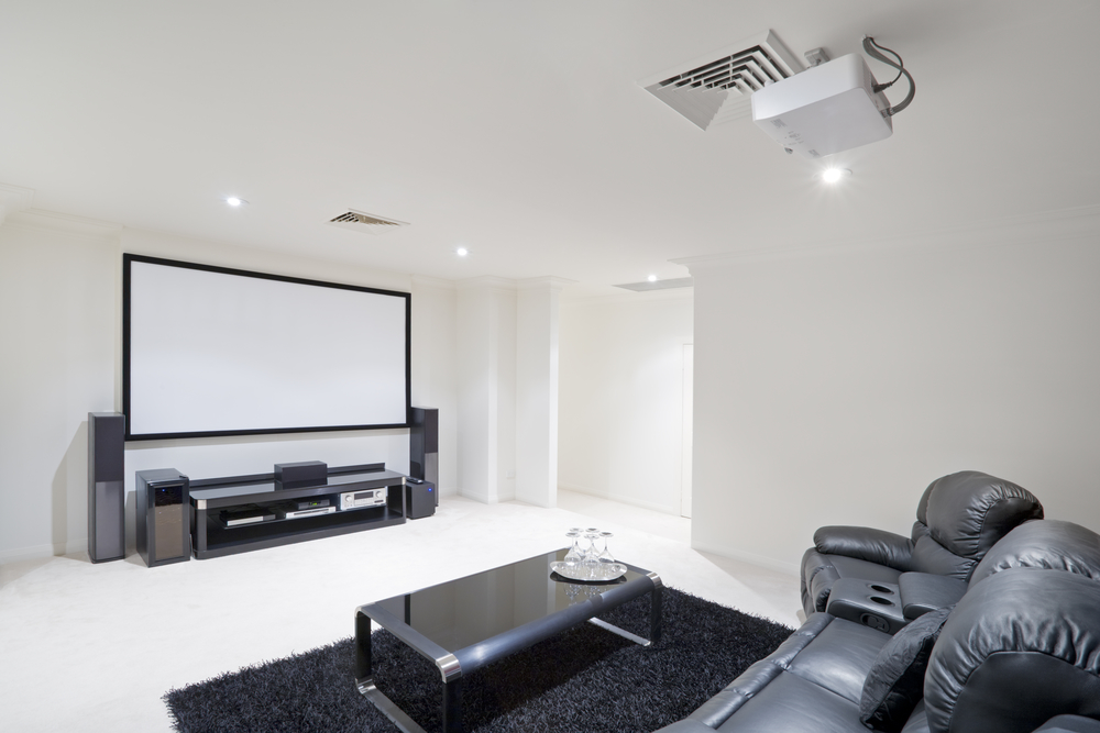 a white home theater room with a couch and television