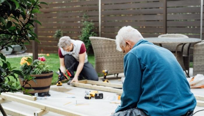 Two people putting in a patio deck