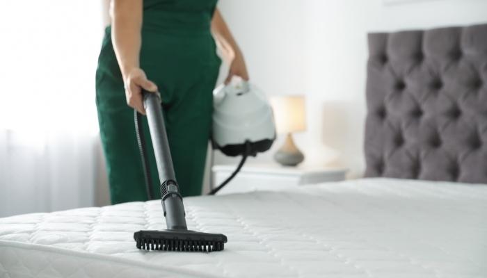 Woman vacuuming mattress