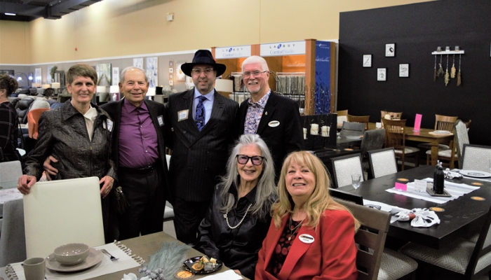 Team members smile at the camera in a showroom