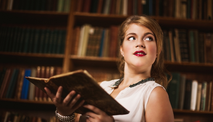 Closeup of a woman reading and old text in a luxury library