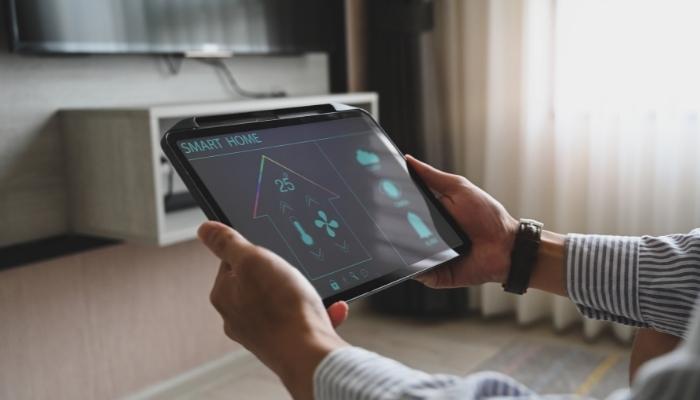 Hands holding a tablet with thermostat info