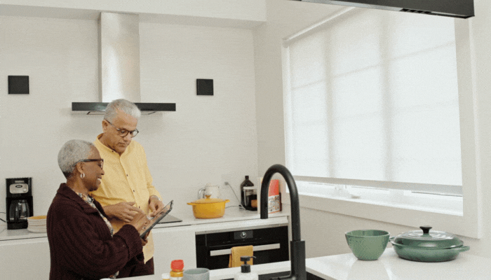 Older couple figuring out how their smart blinds work through the app on their tablet