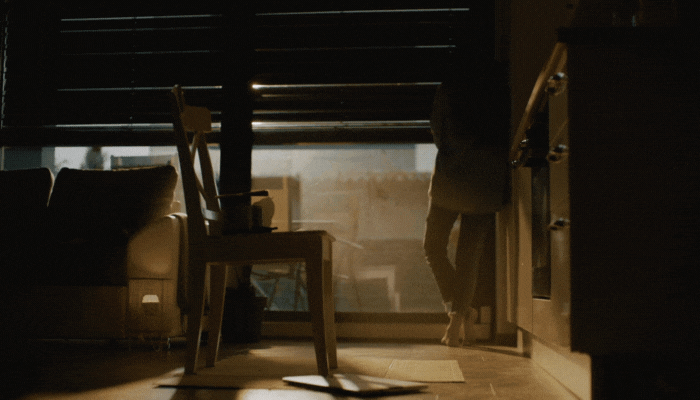 Woman stands in front of windows as they open with the sun; windows are fully exposed to the sun