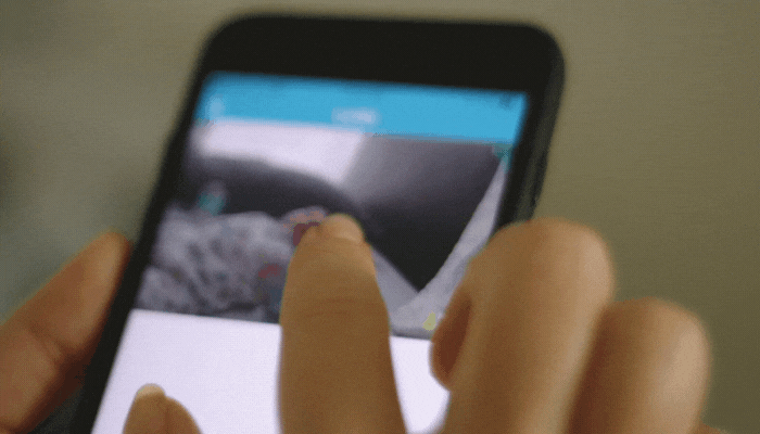 Closeup of woman observing baby on her smartphone