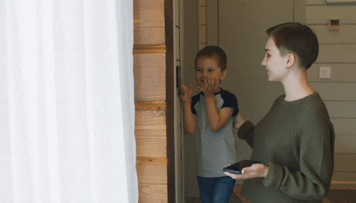 Older sister teaches younger brother how to work the smart door lock