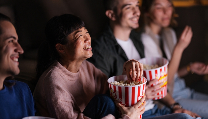 group of friends eating popcorn while watching movie