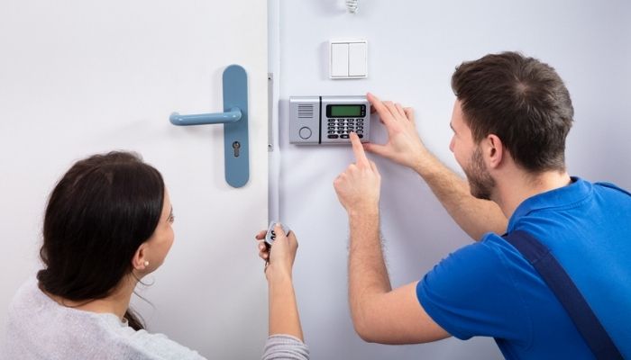 technician installing system and showing client