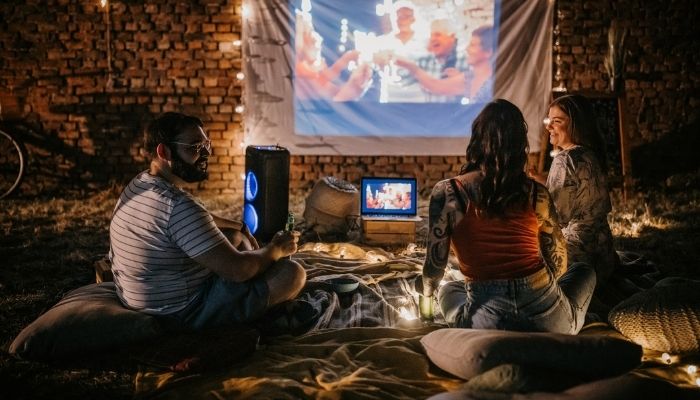 people watching movie outdoors with speaker