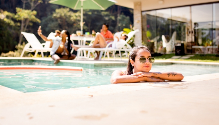 Group of friends hanging out by the pool at a nice house