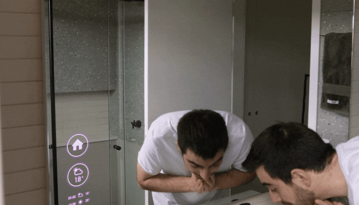 Man uses smart command in front of smart mirror to start a pot of coffee