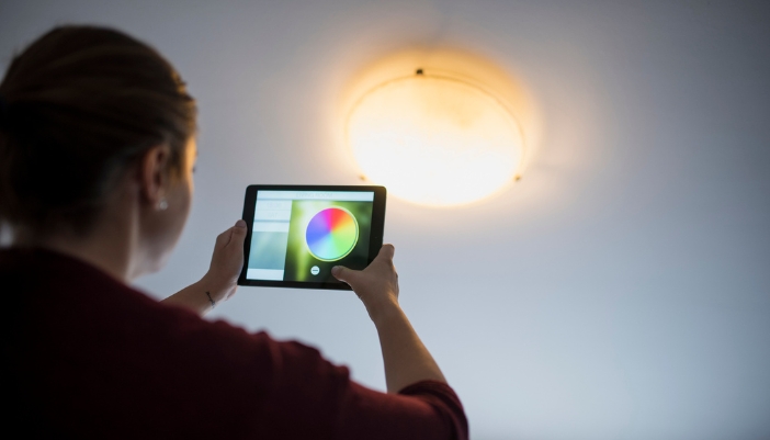 Closeup of a woman changing the color on her smart lights