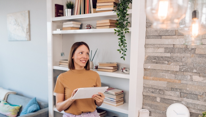 A happy woman adjusting her smart lighting settings