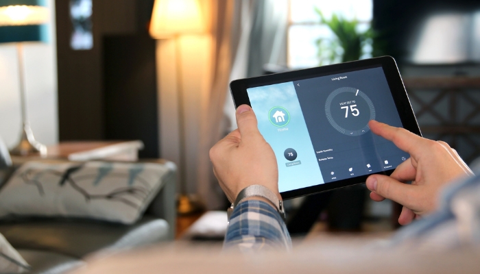Closeup of a man adjusting thermostat through smart control hub