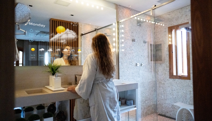 Woman doing her morning routine and check up on the weather in the smart bathroom mirror
