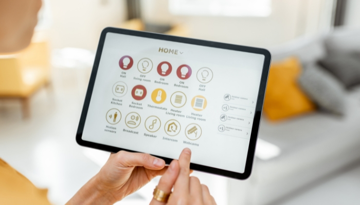 Closeup of woman holding smart home control panel with smart security and other smart home settings