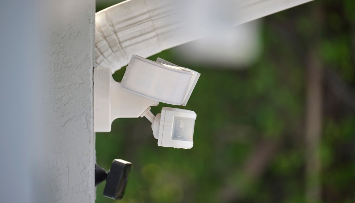 Closeup of a smart sensor and lighting outside connected to the security system