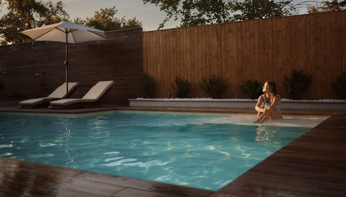 Woman sitting on the shallow steps of pool enjoying the heated waters
