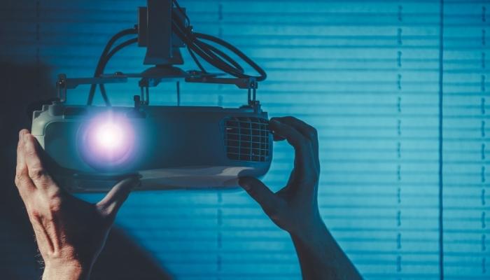 person adjusting projector