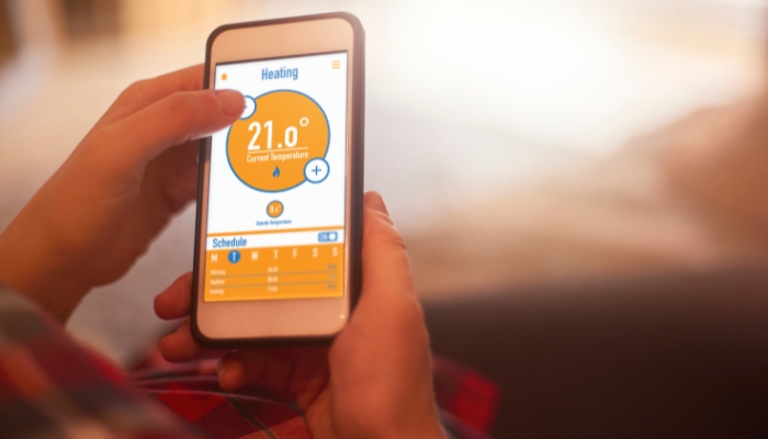 Close up of hand adjusting smart thermostat