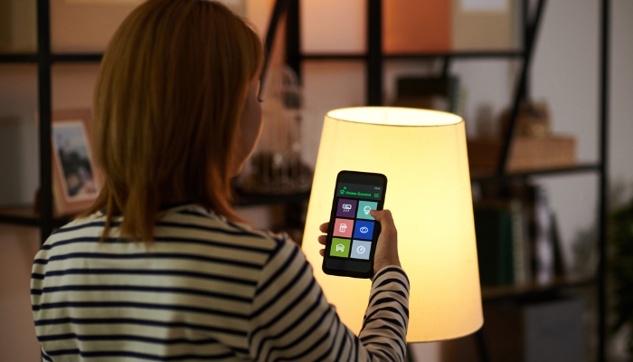 Woman dimming lights from smartphone