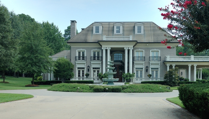 Historical mansion with water fountain, balconies, and columns