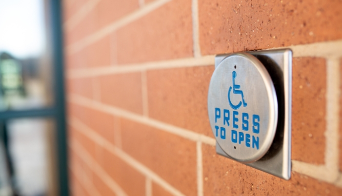 Closeup of a wheelchair accessible button to open the doors, signifies ADA compliance