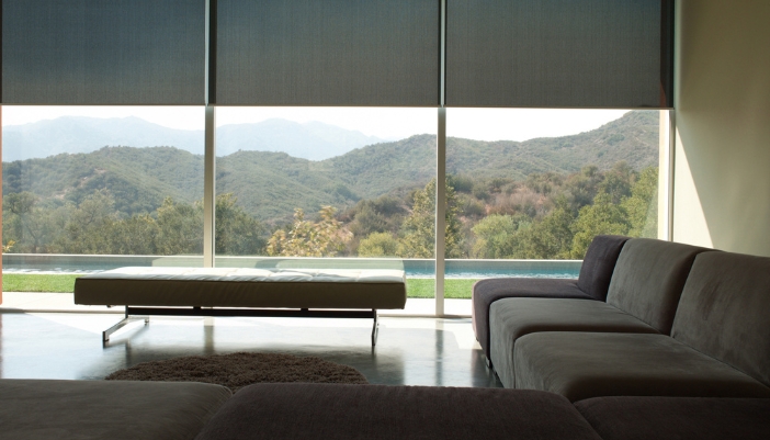 A modern living space with smart shades partially closed to let in the seasonal light