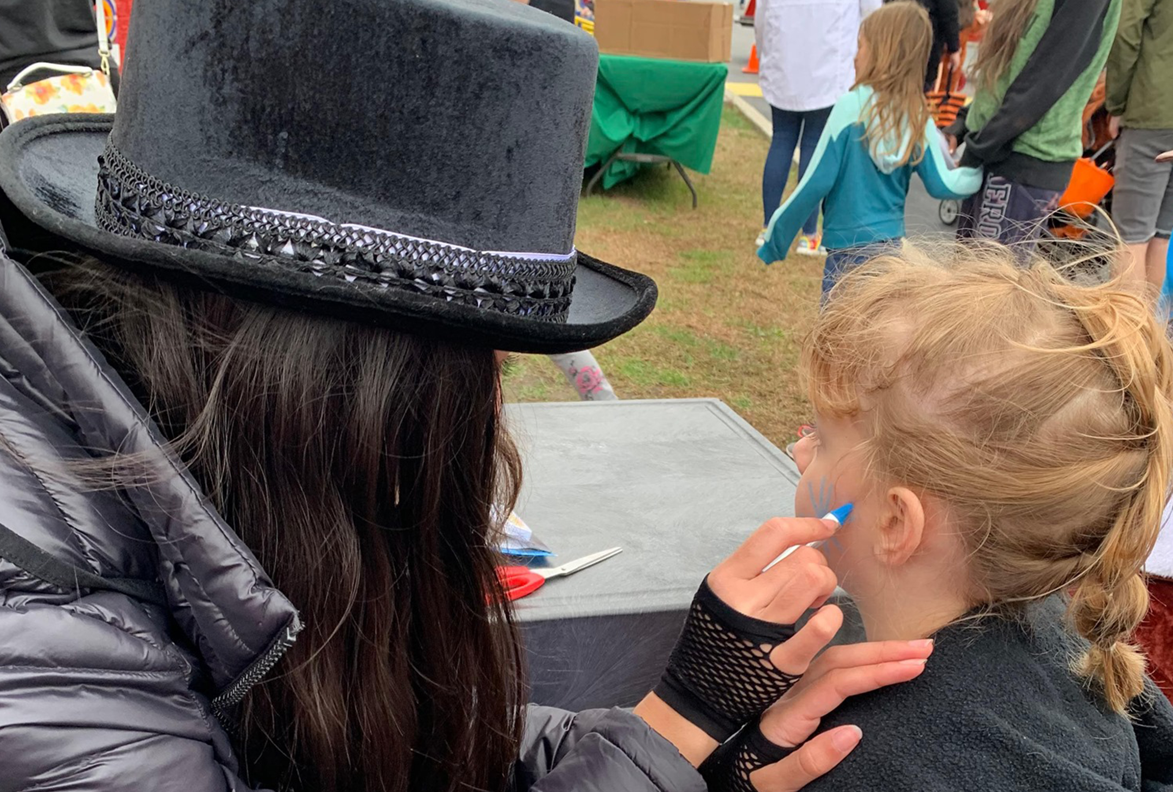 Little girl getting a temporary face painting at Trunk or Treat event