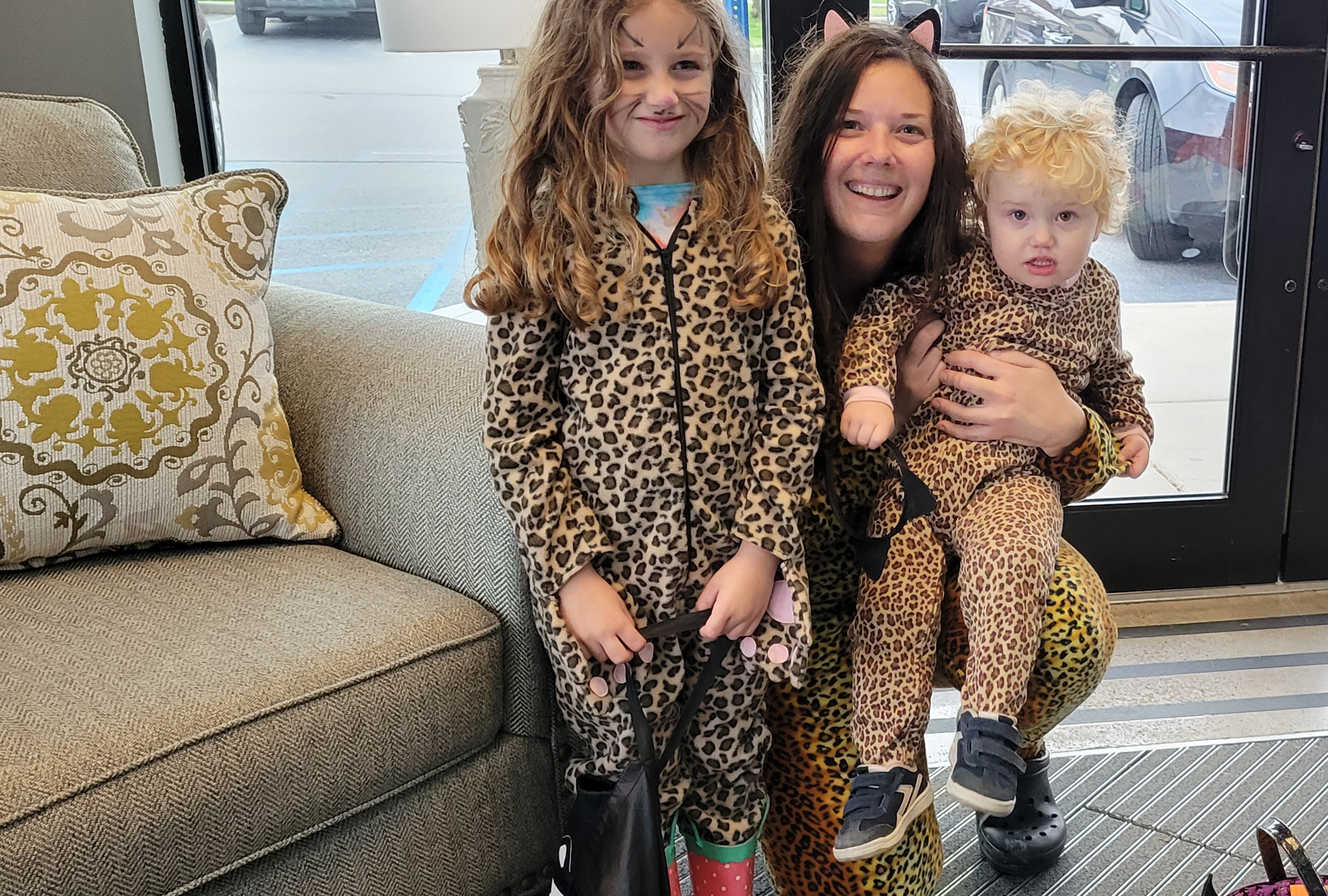 Mother and children in cheetah-print theme pose for the camera