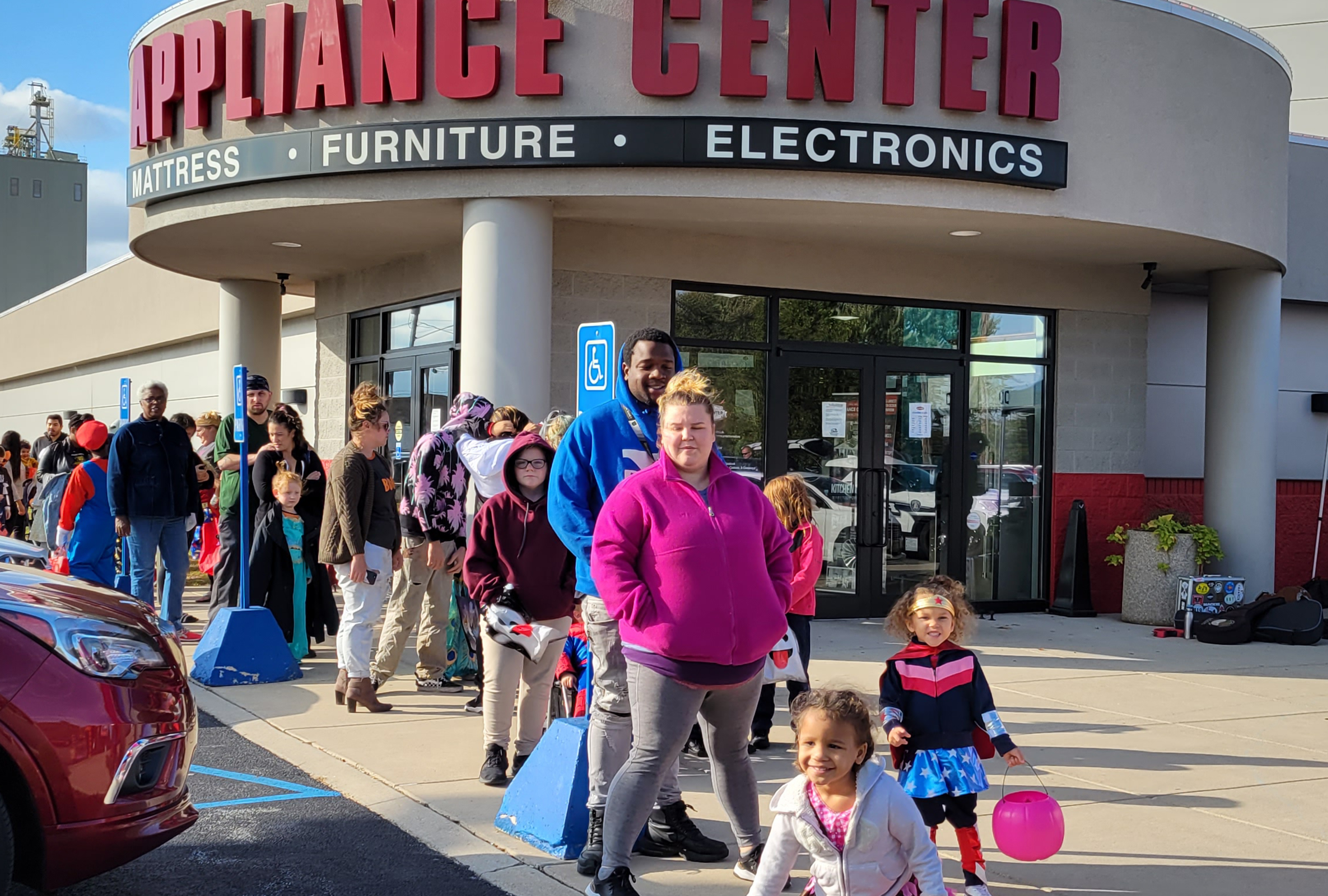 Parents and costumed children in front of Appliance Center of Toledo store