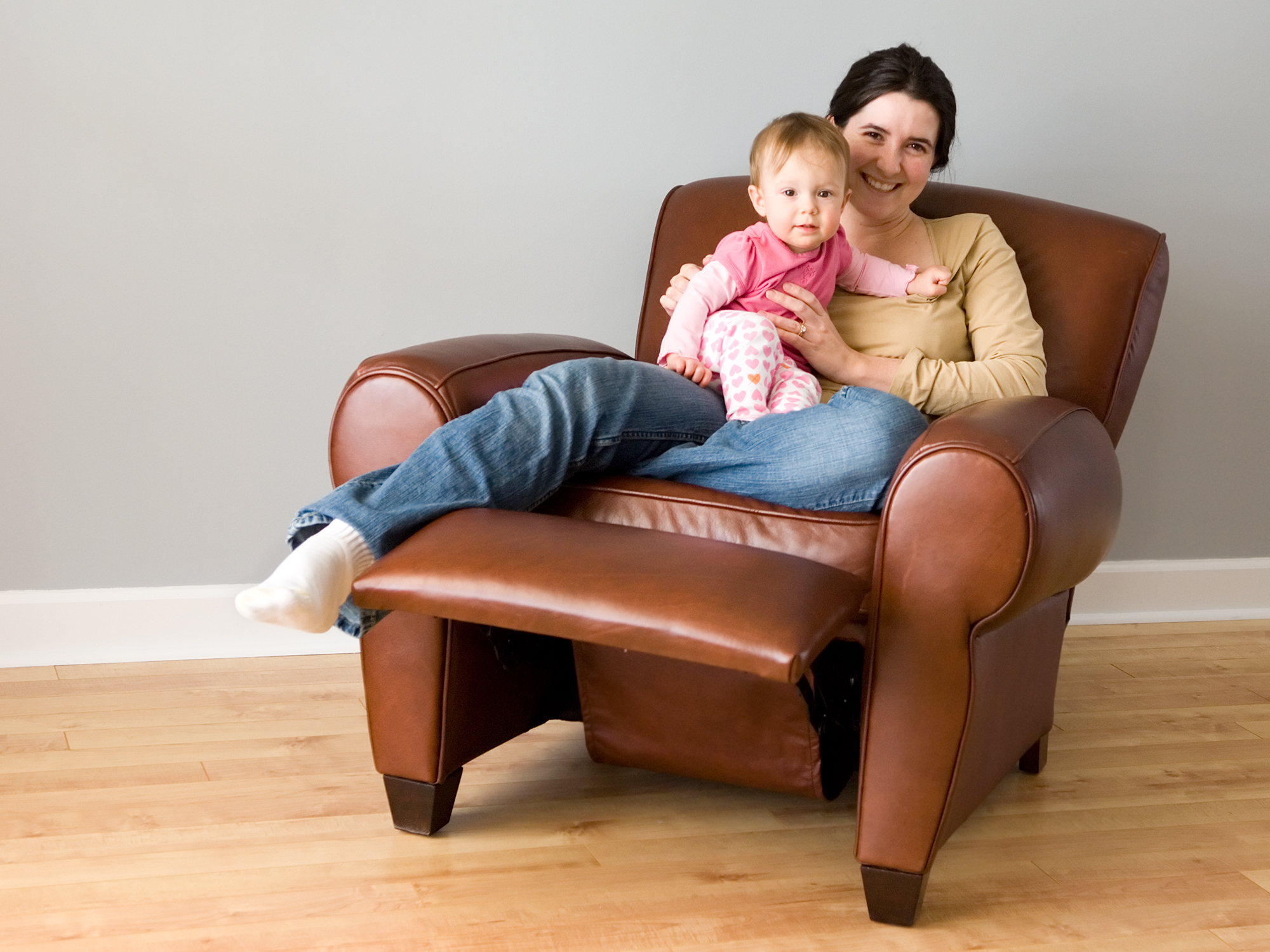 Mother and child smile while sitting in leather recliner