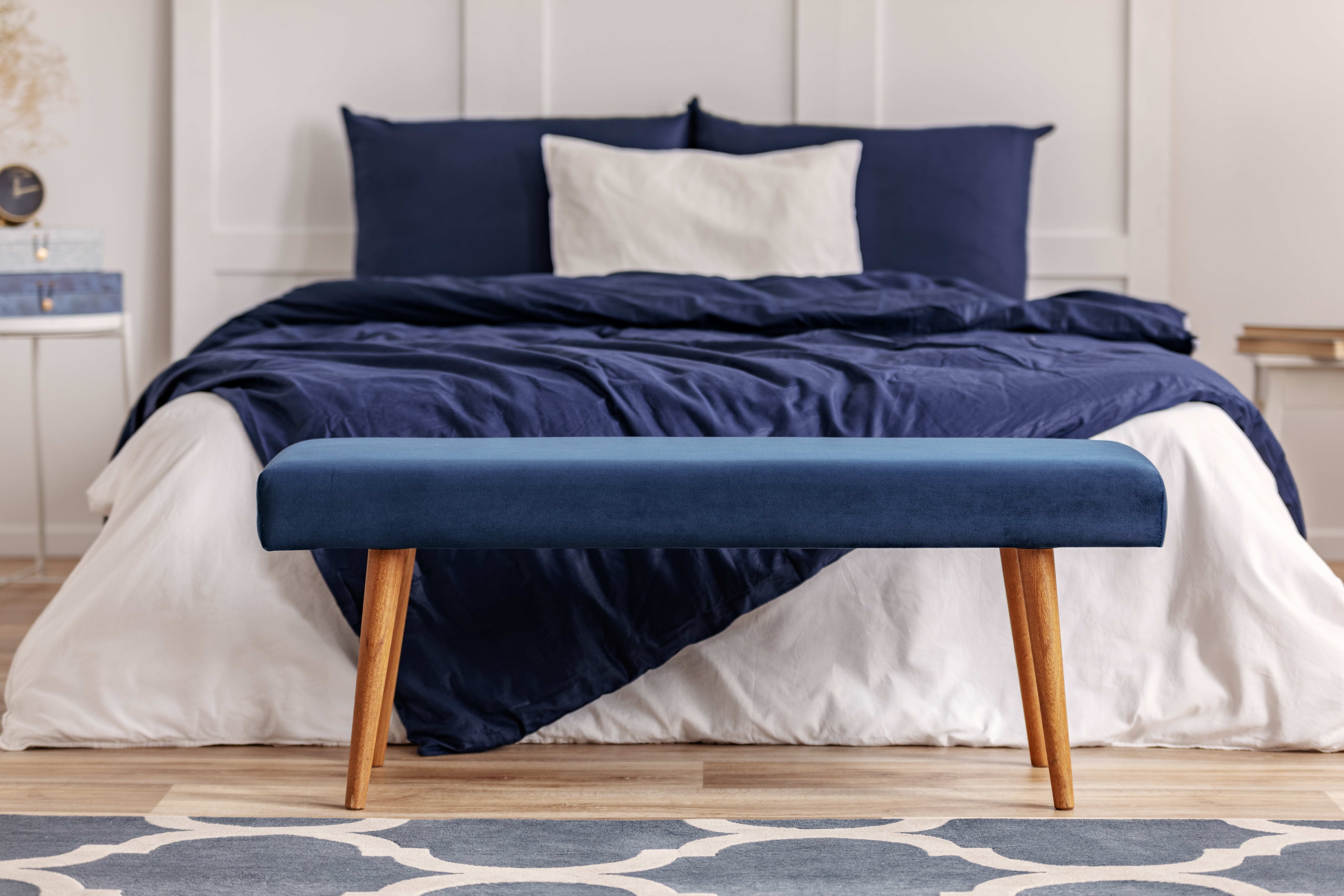 Bed with blue and white comforters with a matching blue bed bench