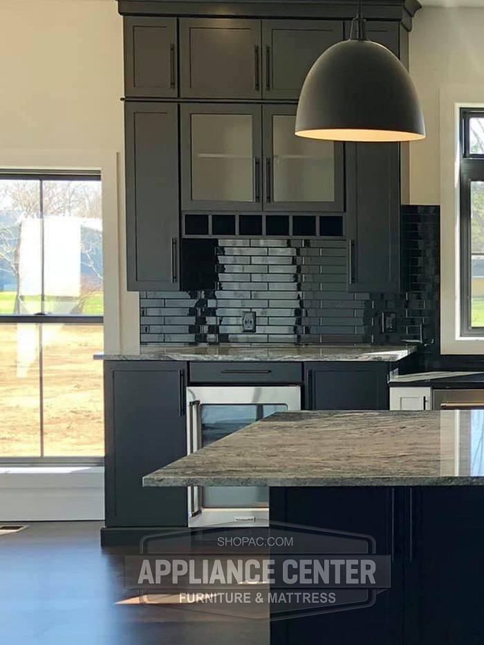 Modern kitchen bar with mini fridge below.