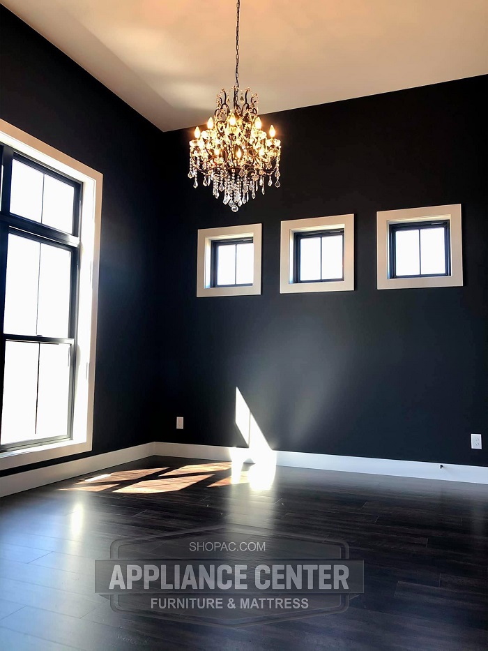 Modern room with wood flooring and a chandelier hanging from the ceiling.