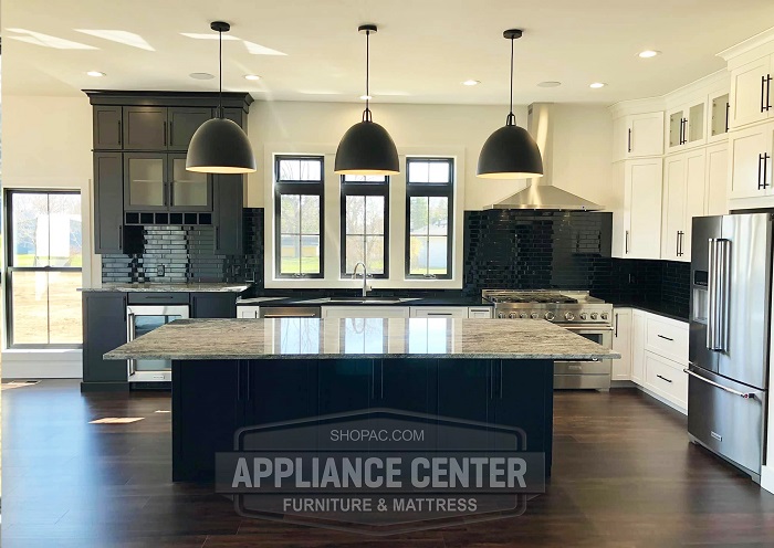 Modern kitchen setup with large counter top island and lighting fixtures.