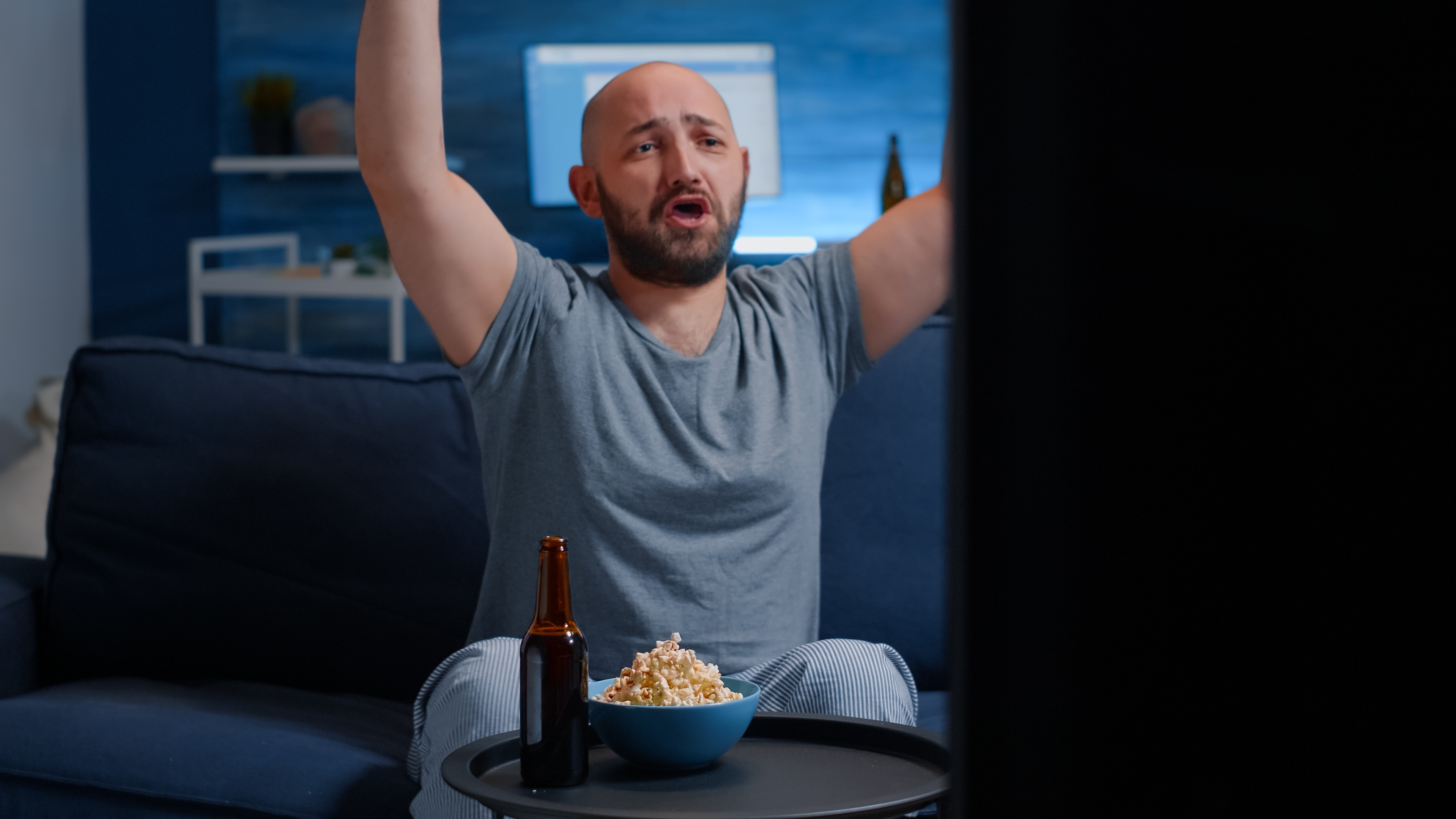 Excited football fan supporting team on television