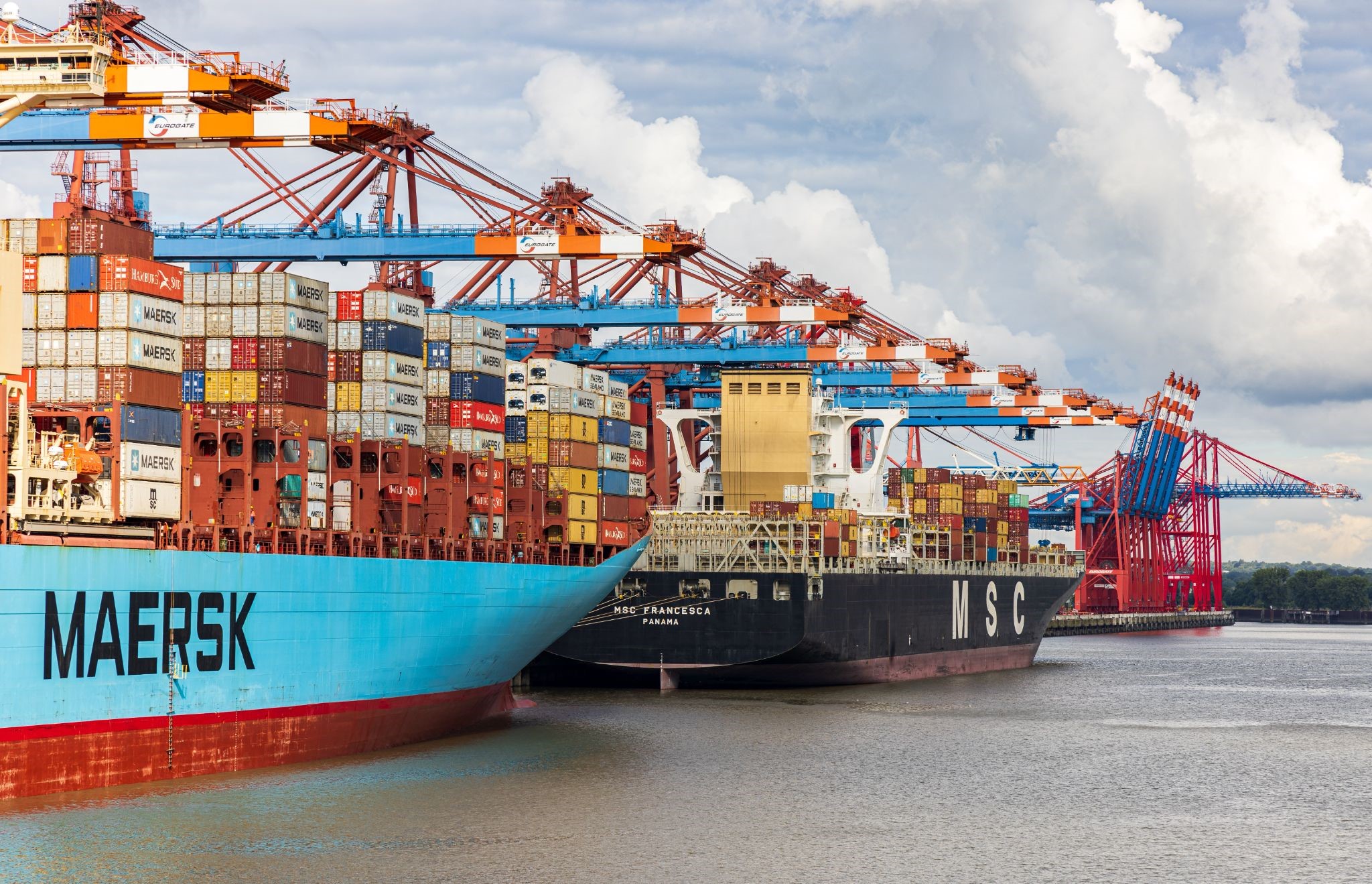 Wide shot of several docked cargo ships