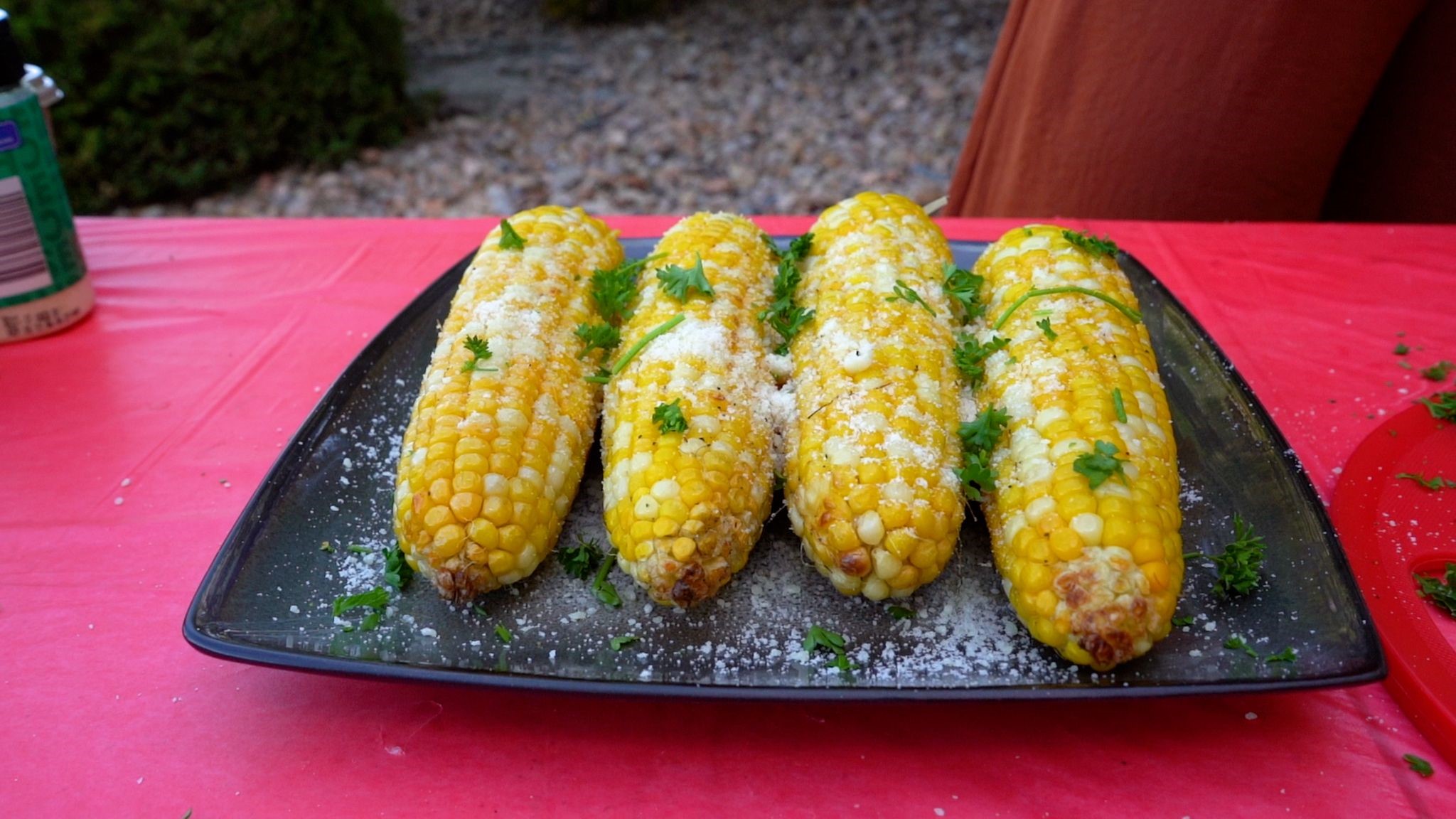 Four ears of corn grilled and topped with butter and herbs