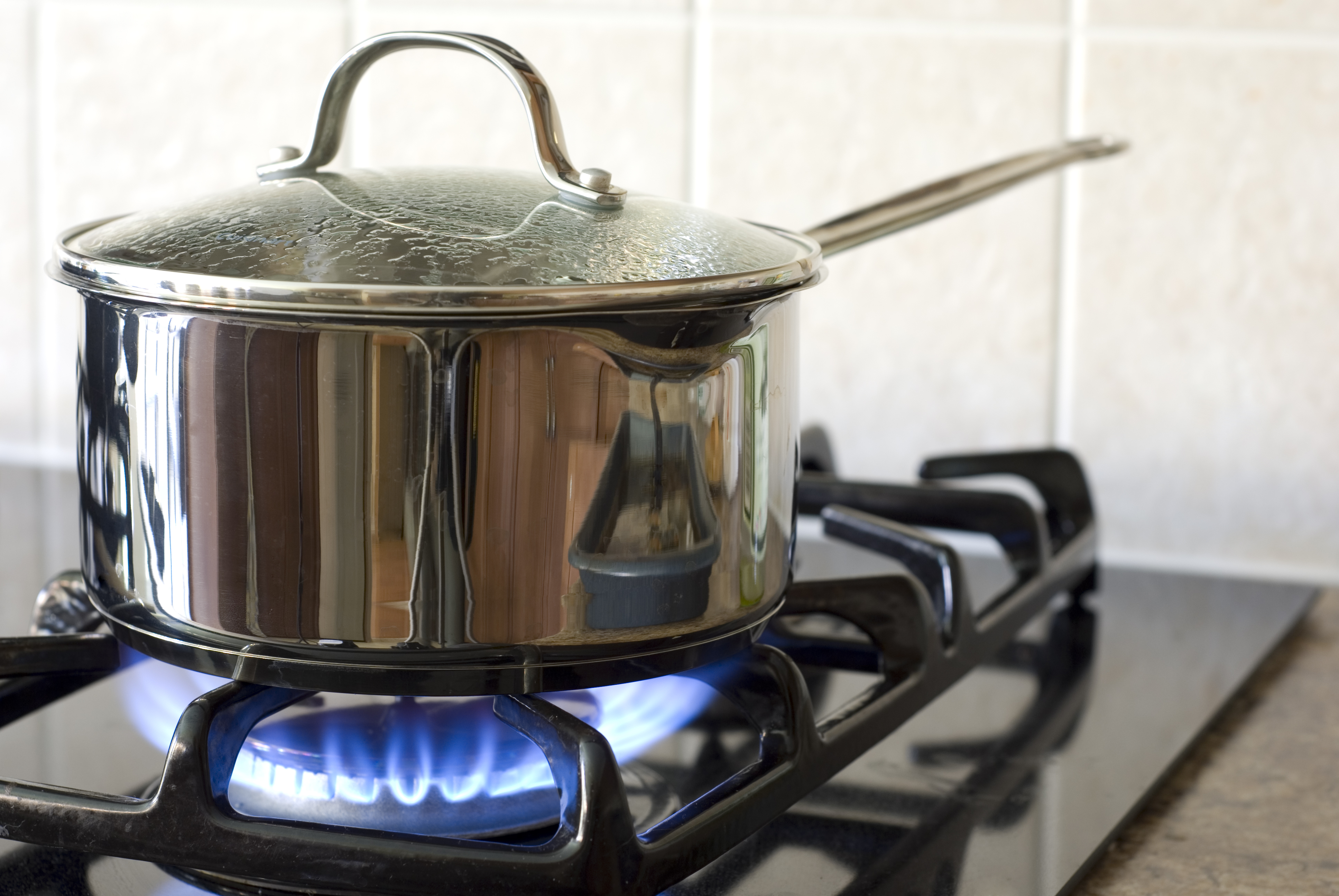 A medium sauce pan cooking over a gas cooktop burner