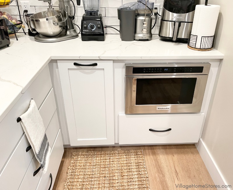 Stainless steel microwave drawer by KitchenAid in a white painted cabinet pantry area. Cabinetry and appliances by Village Home Stores for Aspen Homes of the Quad Cities. 