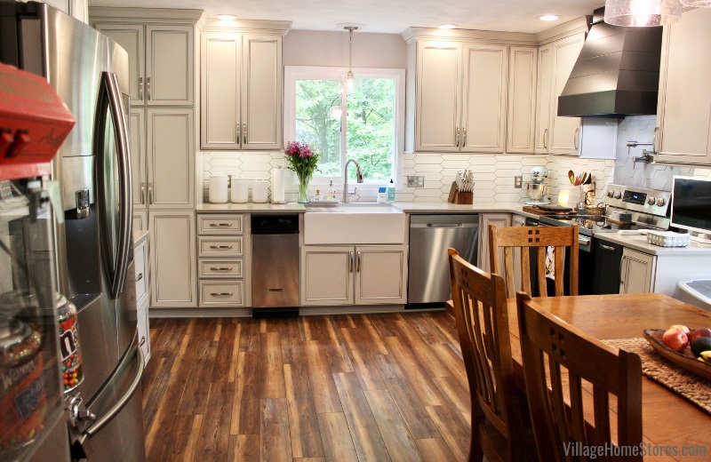 Koch cabinet kitchen with sink underneath the window and a combination of oyster and charcoal blue painted finishes