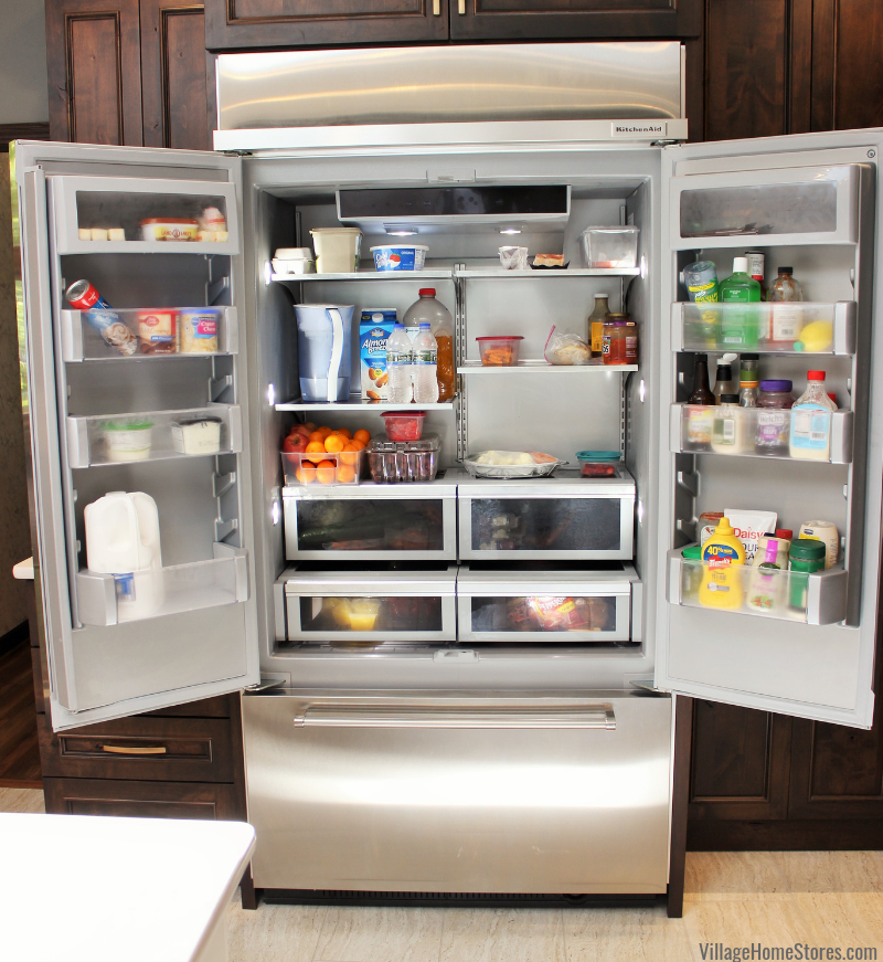 Kitchen with French door refrigerator. Doors open to show interior LED lighting and storage options. 