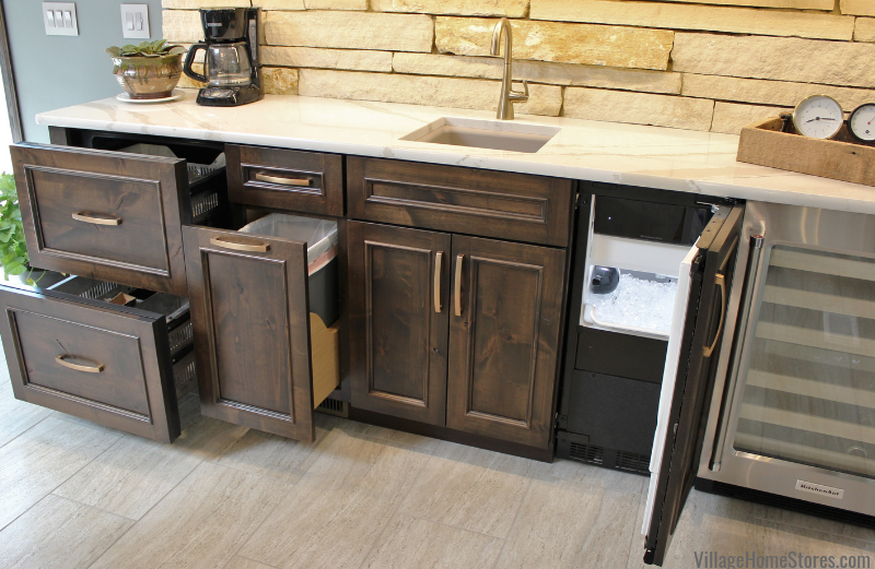 Wet bar cabinet design with panel front refrigerated drawers and pull out trash all shown open.