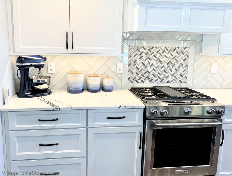 Kitchen with Kitchen Aid front control gas range and white painted cabinets